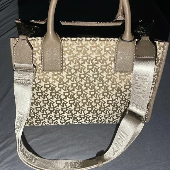 This bag is Tan and brown with a strap, one zipper, two pockets, space inside.